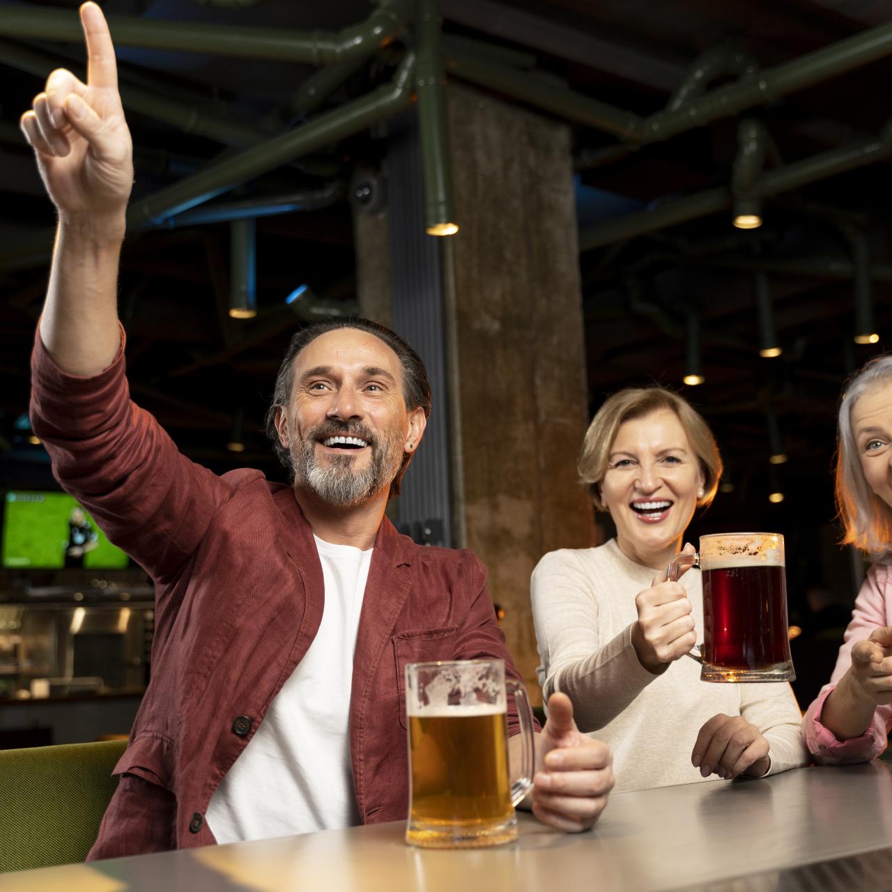 Drei Personen mit Bier lachend